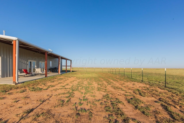 view of yard featuring a rural view and a patio area