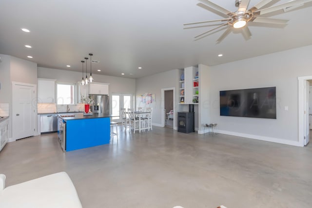 kitchen featuring white cabinets, hanging light fixtures, appliances with stainless steel finishes, and a kitchen island