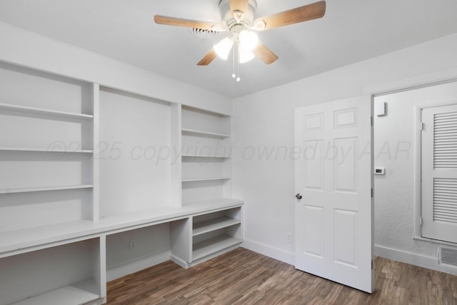 interior space featuring dark wood-style flooring, ceiling fan, and baseboards