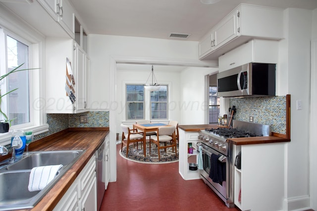 2402 S Hayden St, Amarillo, TX 79109 - kitchen with appliances with stainless steel finishes, butcher block counters, and decorative backsplash