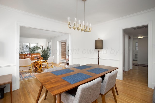 2402 S Hayden St, Amarillo, TX 79109 - dining room with light wood finished floors, crown molding, and a chandelier