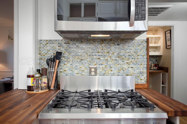 2402 S Hayden St, Amarillo, TX 79109 - kitchen featuring stainless steel microwave, wood counters, stove, and backsplash