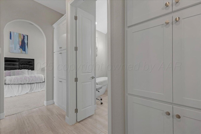 corridor featuring baseboards and light wood-type flooring