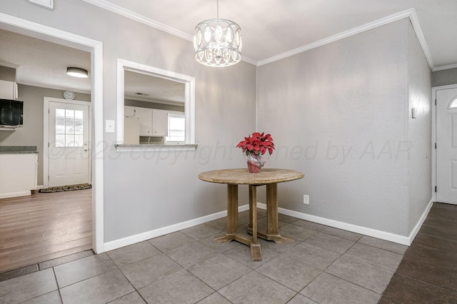 unfurnished dining area with tile patterned flooring, ornamental molding, and a chandelier