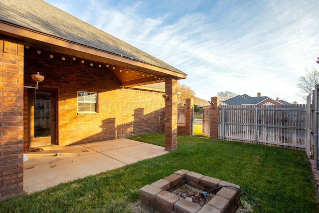 view of yard with a patio, a fire pit, and fence