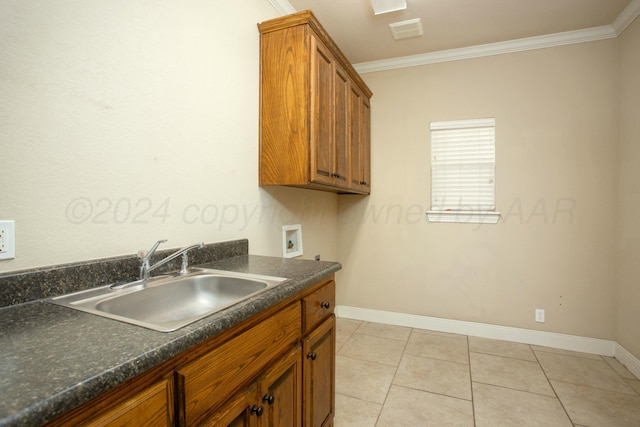 kitchen featuring crown molding, light tile patterned floors, a sink, dark countertops, and brown cabinets