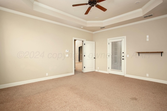 spare room featuring visible vents, baseboards, a ceiling fan, carpet, and a tray ceiling