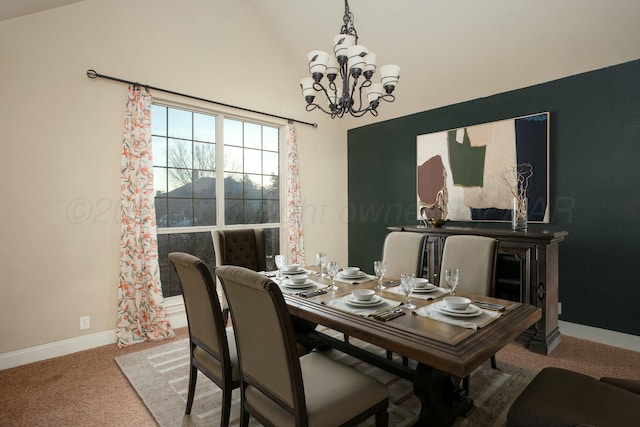 carpeted dining area featuring a notable chandelier, vaulted ceiling, and baseboards