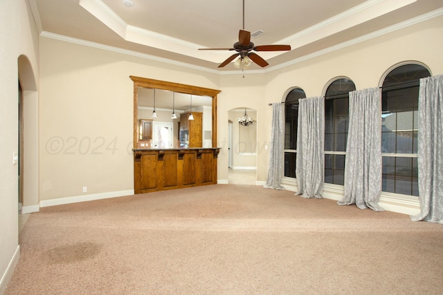 empty room with carpet flooring, a tray ceiling, crown molding, and ceiling fan with notable chandelier