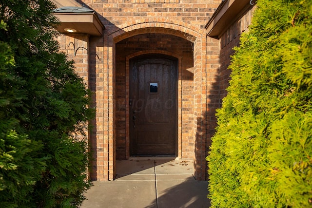 entrance to property featuring brick siding