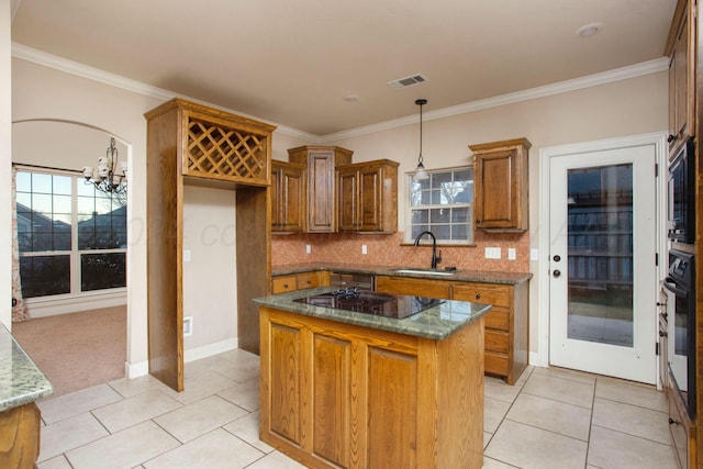 kitchen featuring tasteful backsplash, a sink, light tile patterned floors, brown cabinets, and black appliances