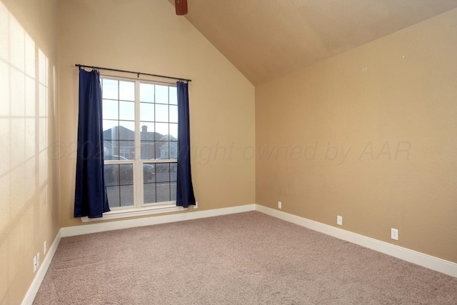 carpeted spare room featuring high vaulted ceiling and baseboards