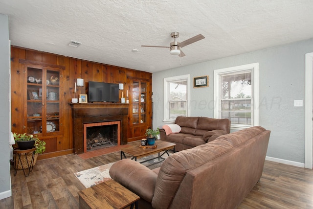 living area with a ceiling fan, wood finished floors, and wooden walls