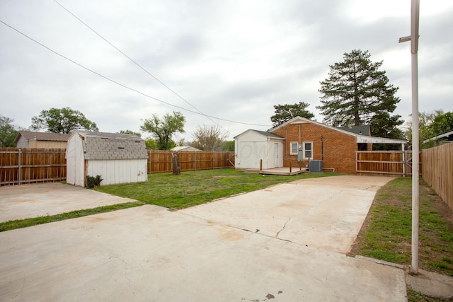 view of yard with a fenced backyard, an outdoor structure, a patio area, and a storage shed