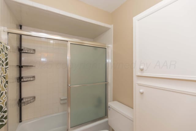 1506 S Alabama St, Amarillo, TX 79102 - bathroom featuring toilet and bath / shower combo with glass door