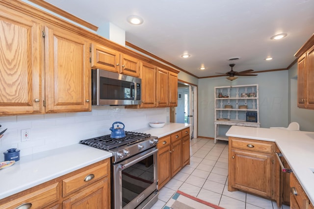 kitchen featuring tasteful backsplash, light countertops, appliances with stainless steel finishes, and a ceiling fan