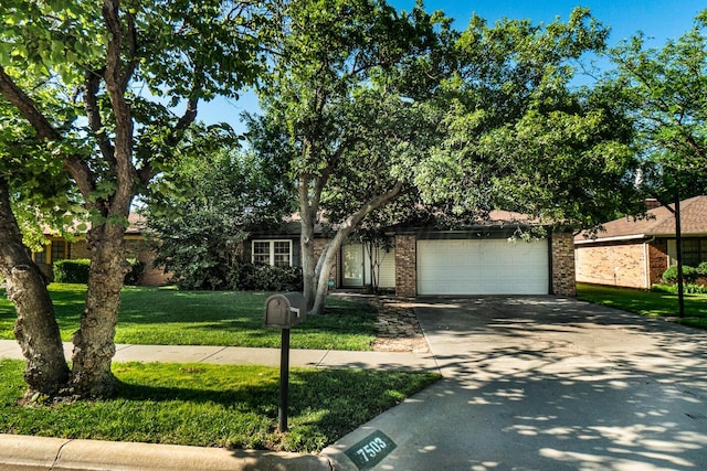 7503 Elmhurst Dr, Amarillo, TX 79121 - obstructed view of property with brick siding, a garage, a front yard, and concrete driveway