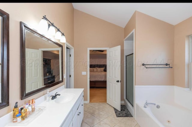 ensuite bathroom featuring tile patterned floors, vaulted ceiling, vanity, a whirlpool tub, and a shower stall