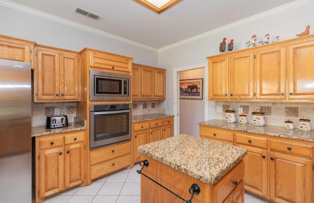 kitchen with stainless steel appliances, tasteful backsplash, ornamental molding, a kitchen island, and light tile patterned flooring
