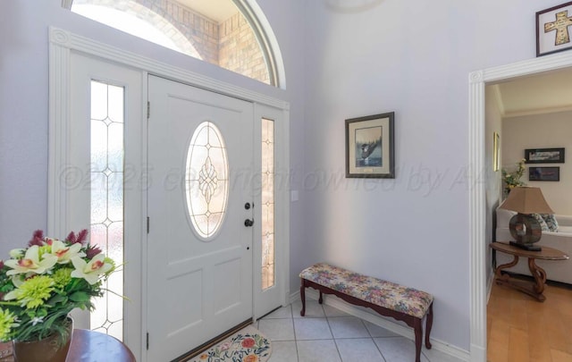 entrance foyer with baseboards and ornamental molding
