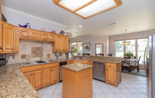 kitchen with appliances with stainless steel finishes, a peninsula, a sink, crown molding, and plenty of natural light