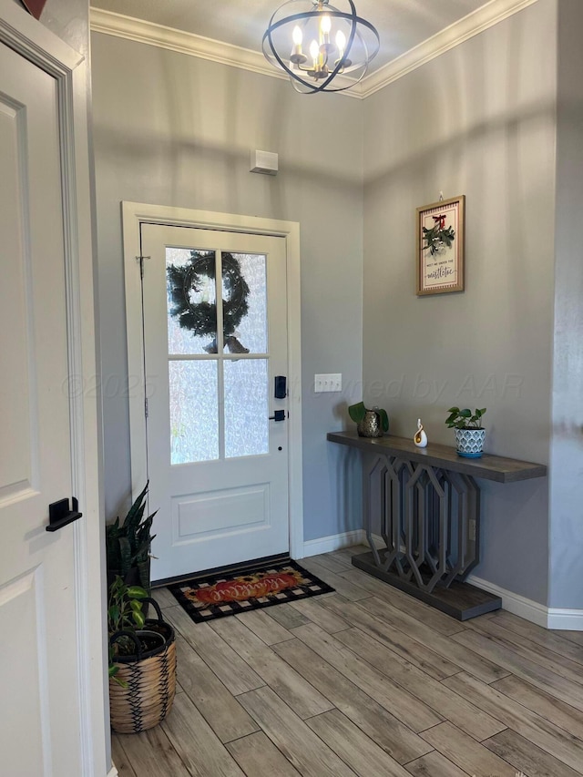 entrance foyer featuring light hardwood / wood-style flooring, crown molding, and a notable chandelier