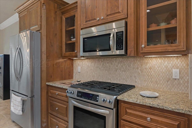 19550 Saddlehorn Rd, Amarillo, TX 79119 - kitchen featuring stainless steel appliances, brown cabinetry, light stone counters, and crown molding