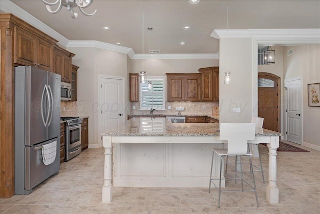 19550 Saddlehorn Rd, Amarillo, TX 79119 - kitchen with appliances with stainless steel finishes, a chandelier, crown molding, decorative backsplash, and a breakfast bar area