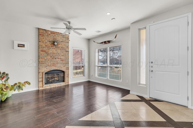 living room featuring a brick fireplace, hardwood / wood-style flooring, and ceiling fan