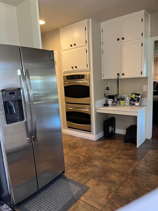 kitchen with baseboards, white cabinetry, light countertops, and appliances with stainless steel finishes