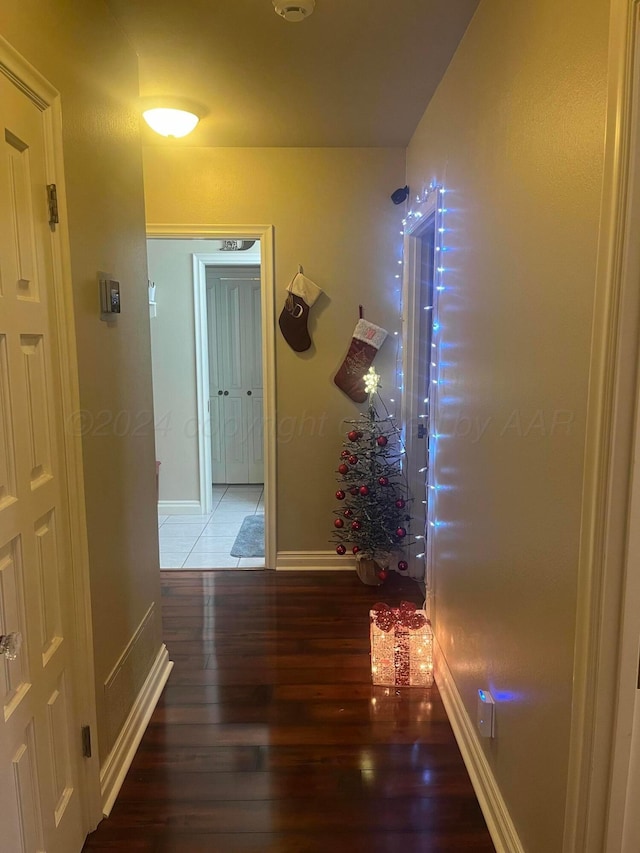 hallway featuring baseboards and wood finished floors
