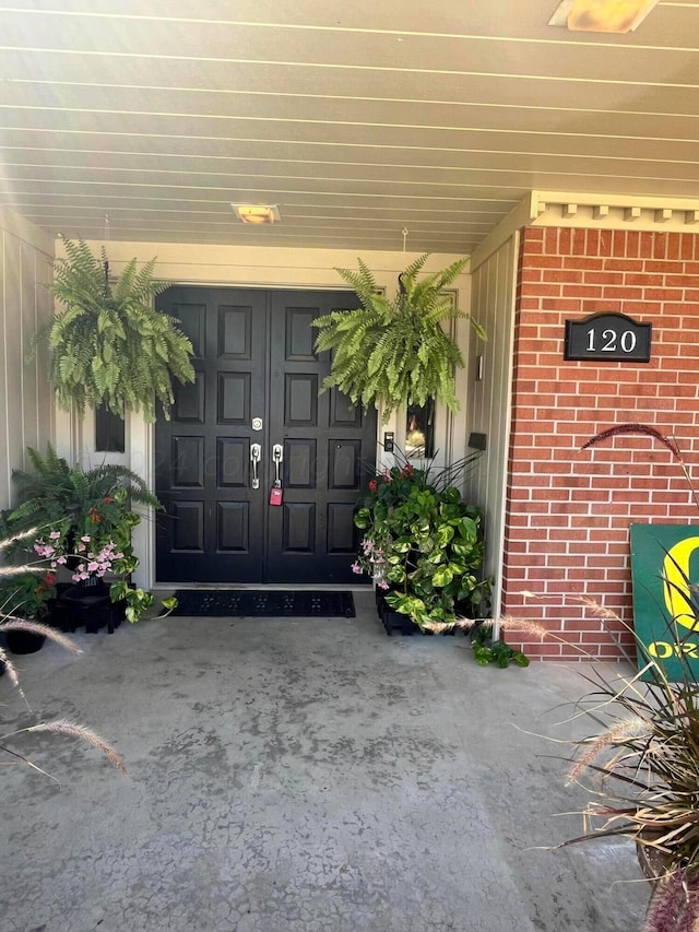 entrance to property with brick siding and a porch