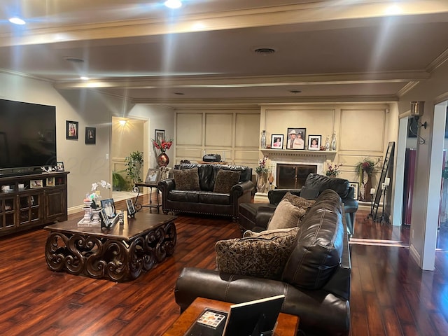 living area featuring visible vents, crown molding, a decorative wall, and hardwood / wood-style floors
