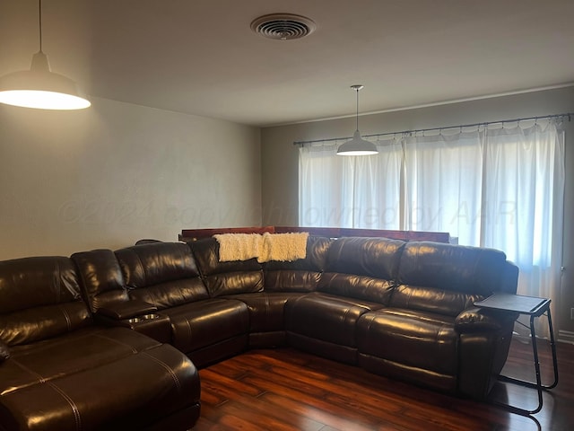 living area with visible vents and wood finished floors