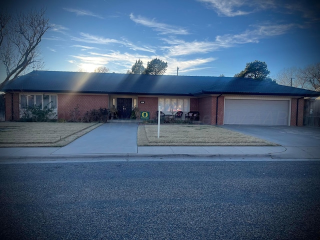 ranch-style house featuring brick siding, concrete driveway, and a garage