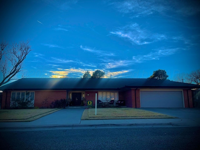 ranch-style home featuring brick siding, a front yard, driveway, and a garage