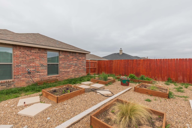 view of yard featuring fence and a vegetable garden