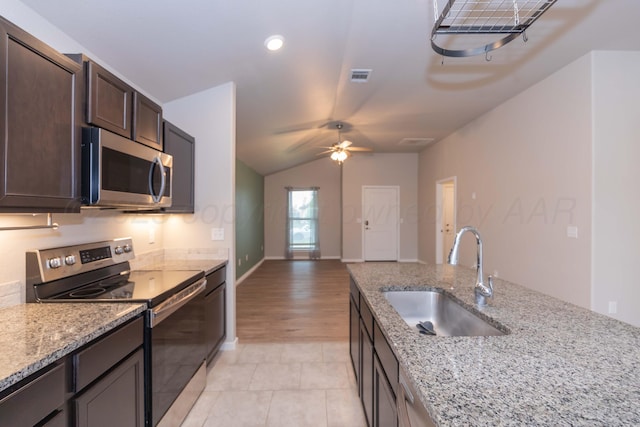 kitchen with visible vents, dark brown cabinets, a sink, lofted ceiling, and stainless steel appliances