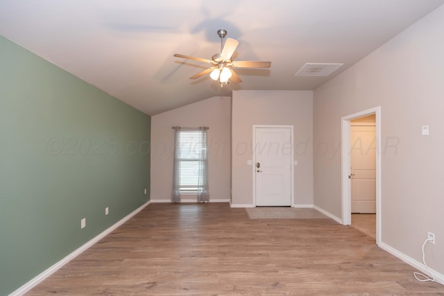 unfurnished room featuring light wood-style floors, baseboards, a ceiling fan, and vaulted ceiling