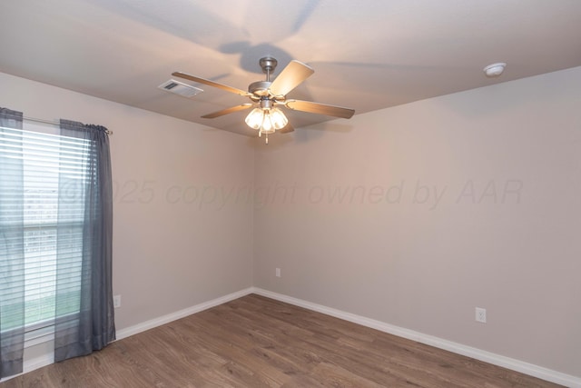 empty room featuring baseboards, ceiling fan, wood finished floors, and visible vents