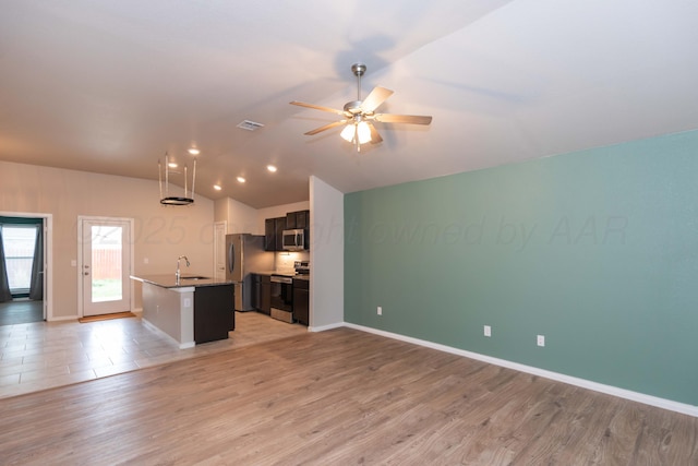 kitchen featuring visible vents, a sink, open floor plan, and stainless steel appliances