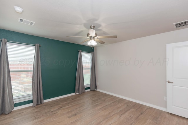unfurnished room featuring ceiling fan, visible vents, baseboards, and light wood-style floors