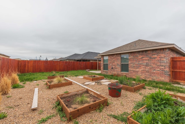 view of yard featuring a fenced backyard and a garden