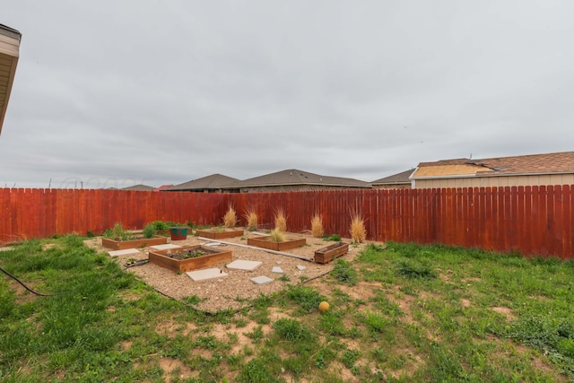 view of yard with a fenced backyard and a garden