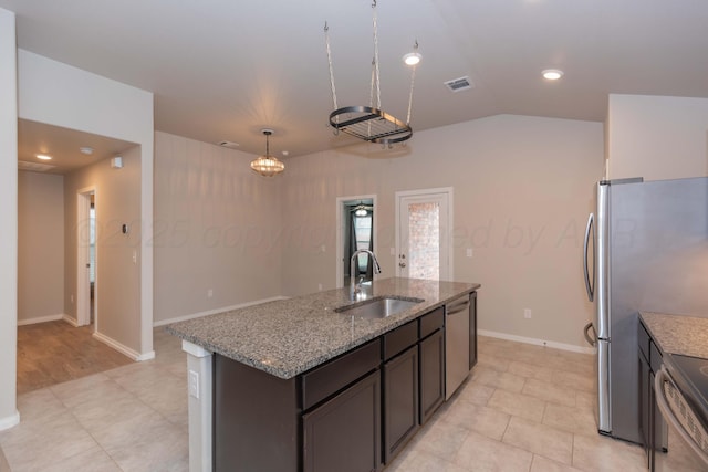 kitchen with visible vents, a sink, appliances with stainless steel finishes, and light stone counters