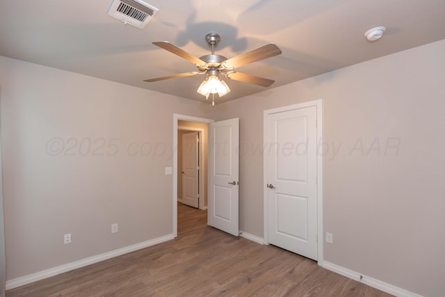 unfurnished bedroom featuring visible vents, a ceiling fan, baseboards, and wood finished floors