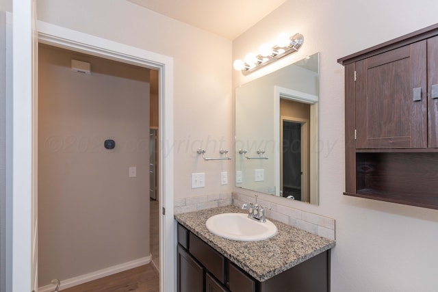 bathroom with vanity, baseboards, and wood finished floors