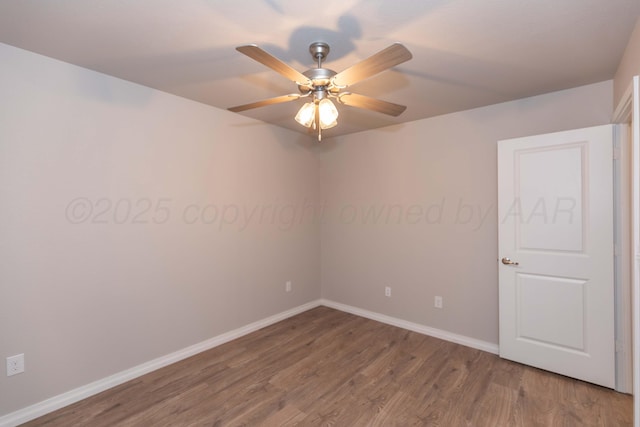 spare room with baseboards, ceiling fan, and wood finished floors