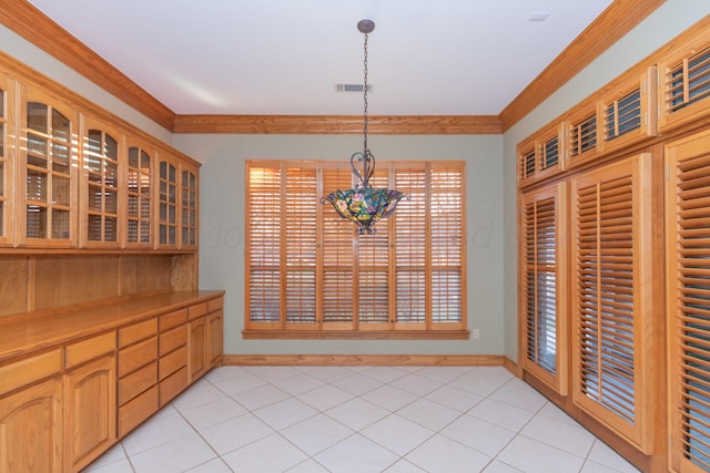 dining space featuring crown molding and light tile patterned floors