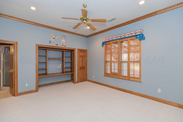 carpeted spare room featuring ornamental molding and ceiling fan